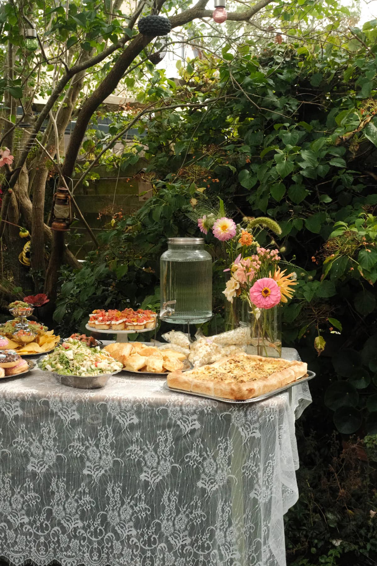 Buffettafel met hapjes en bloemen in een groene tuin