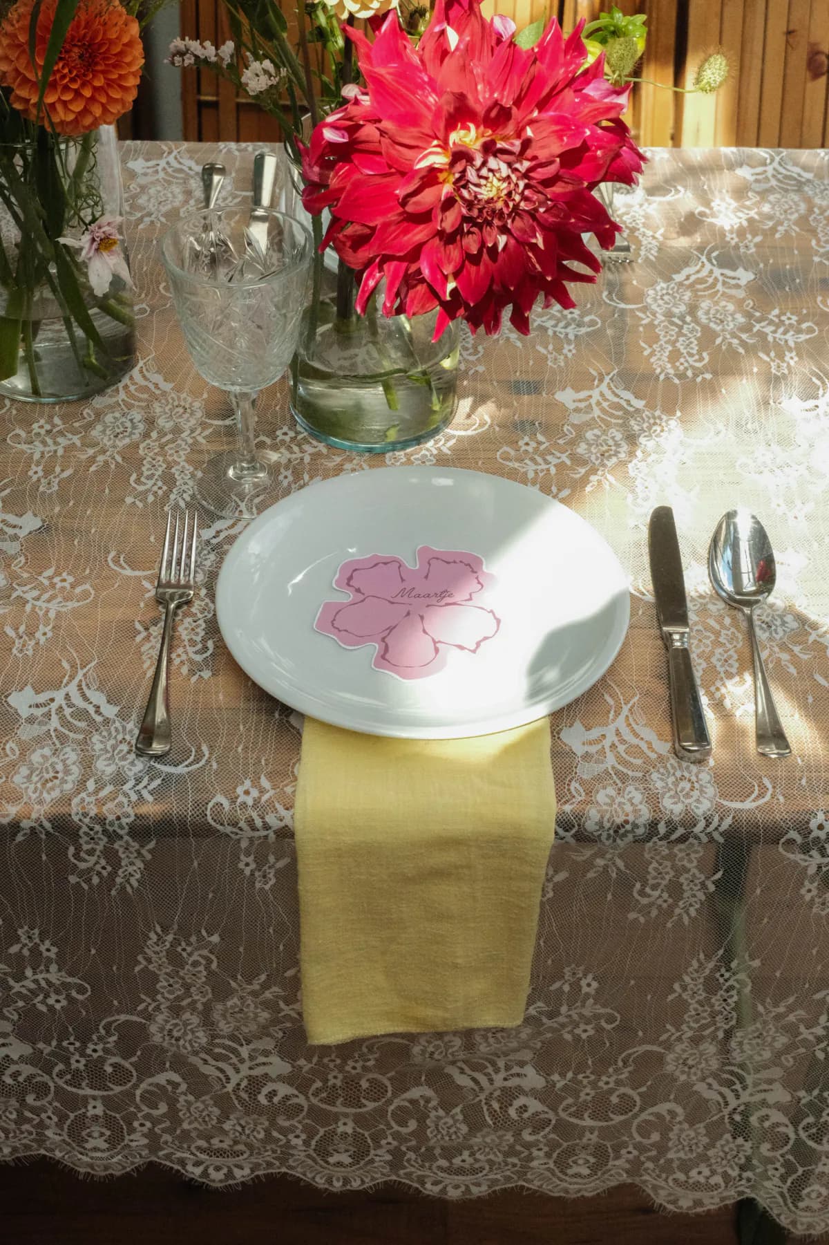 Couverte met vintage servies, kanten tafellinnen en een roze bloemkaartje