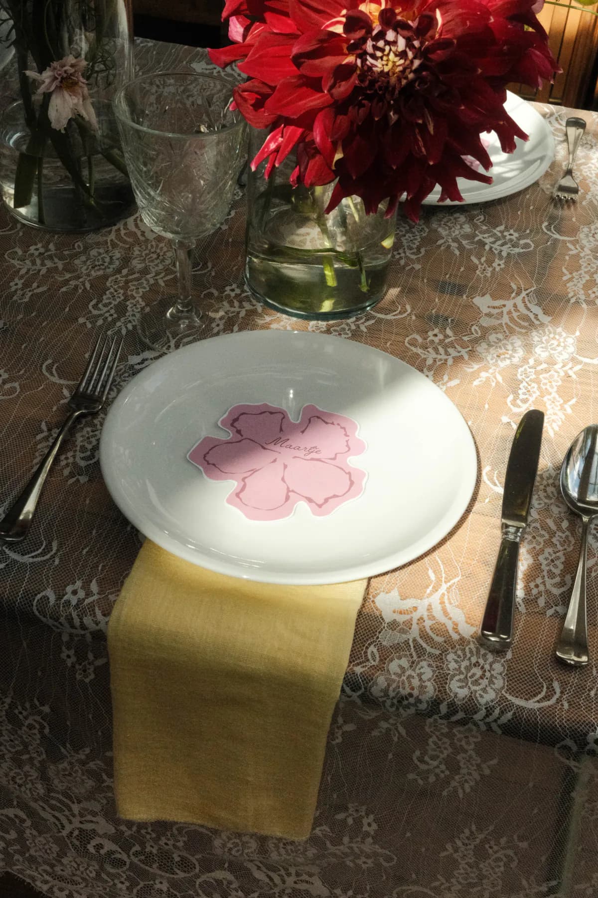 Couverte met vintage servies, kanten tafellinnen en een roze bloemkaartje