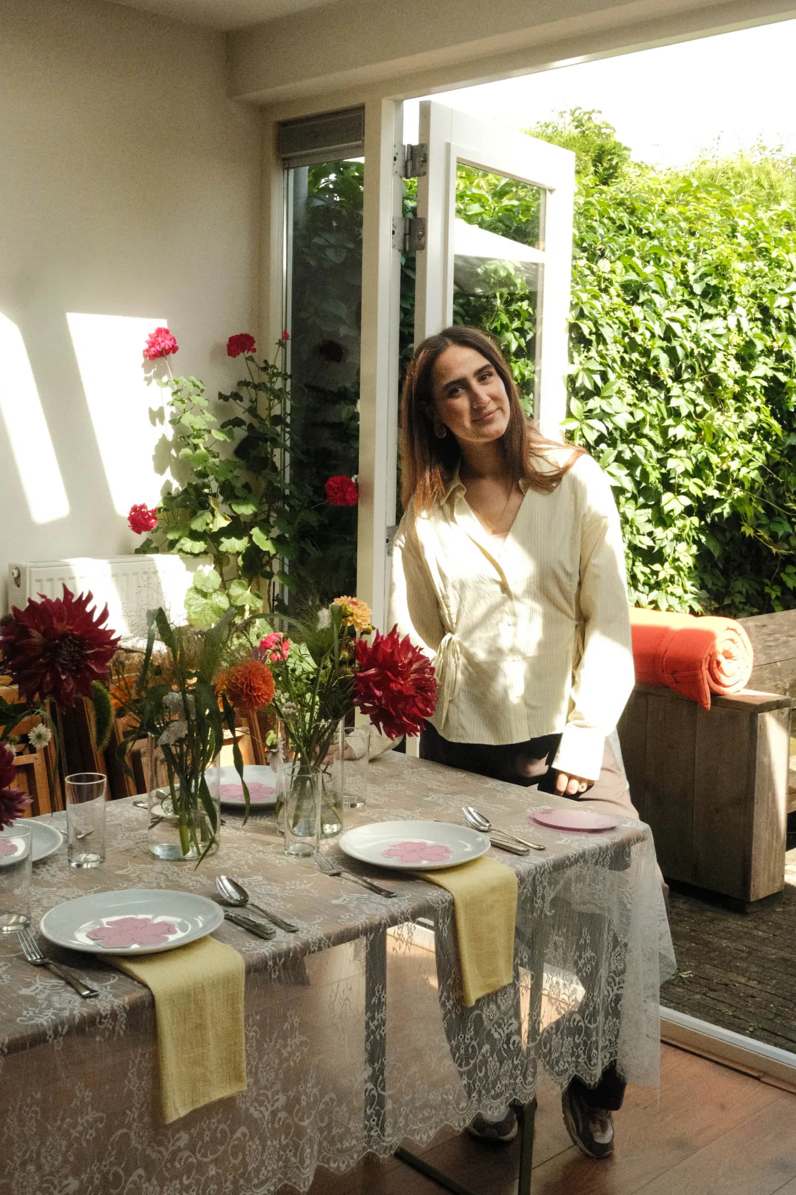 Eventstylist bij een met bloemen en vintage servies gedekte tafel
