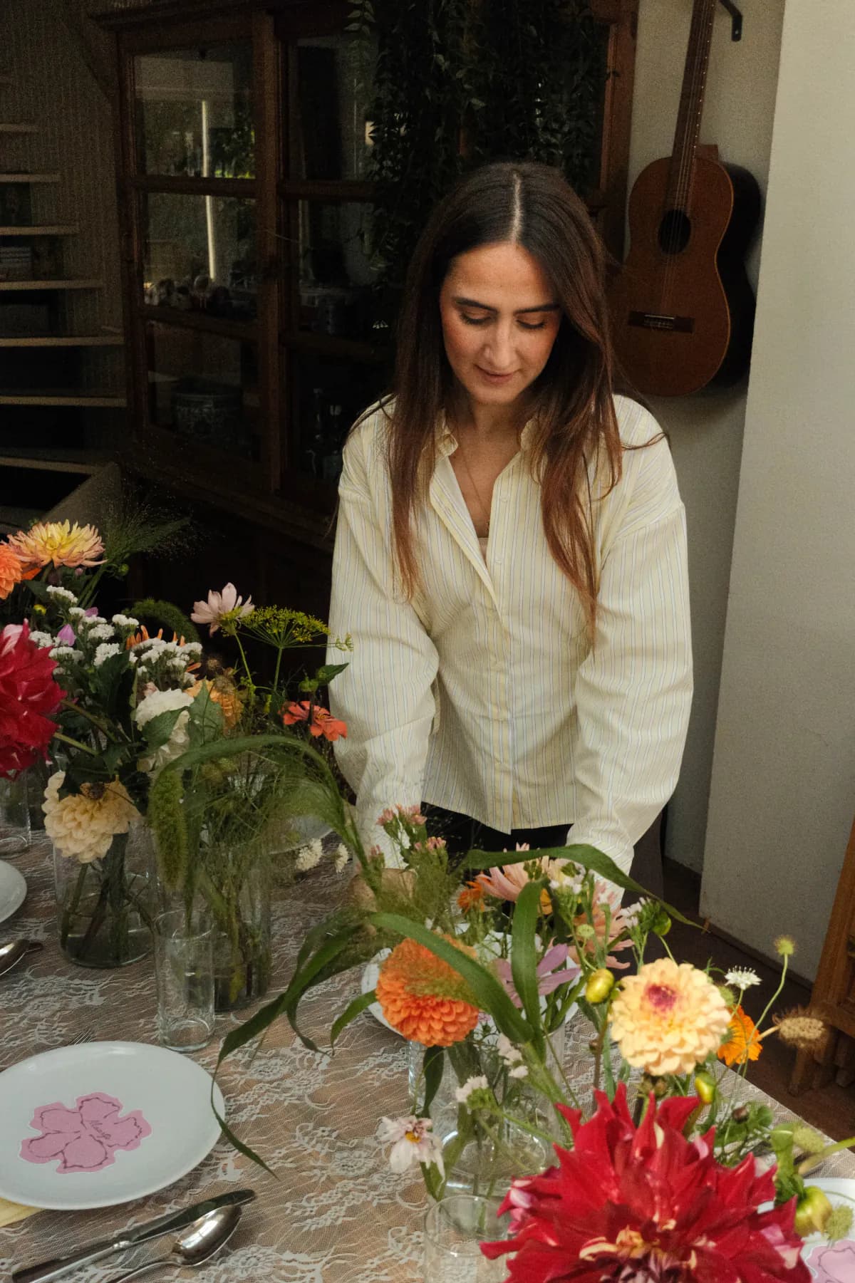 Eventstylist schikt kleurrijke bloemen op een gedekte tafel