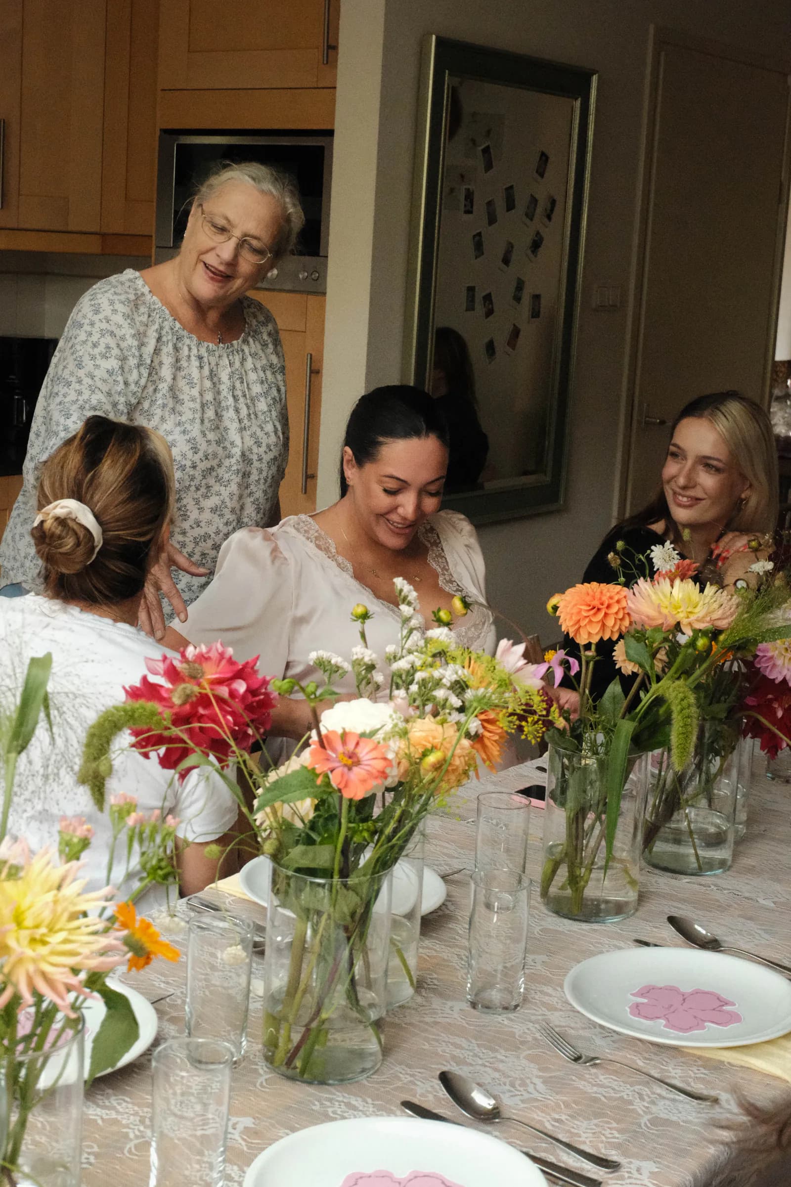 Gasten aan een bloemrijk gestylede tafel tijdens een babyshower