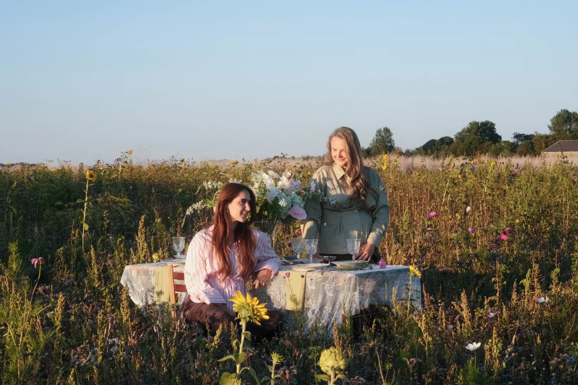De eventstylisten van The Muse Table aan een dinertafel in een bloemenveld