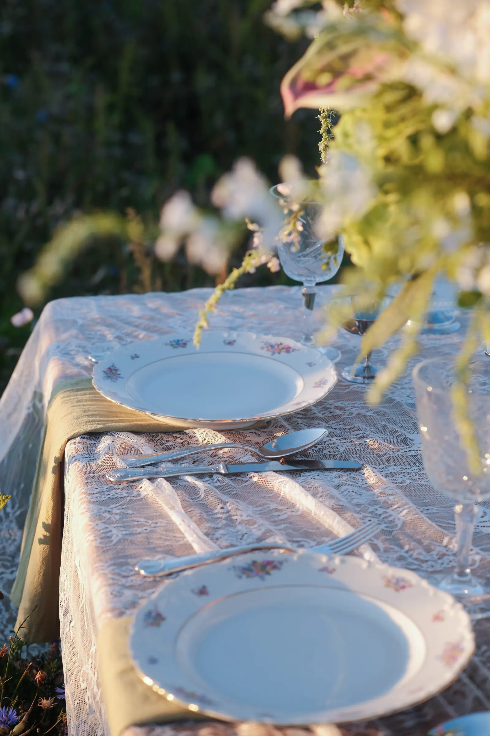 Vintage servies en bloemen op een gedekte private-dinnertafel