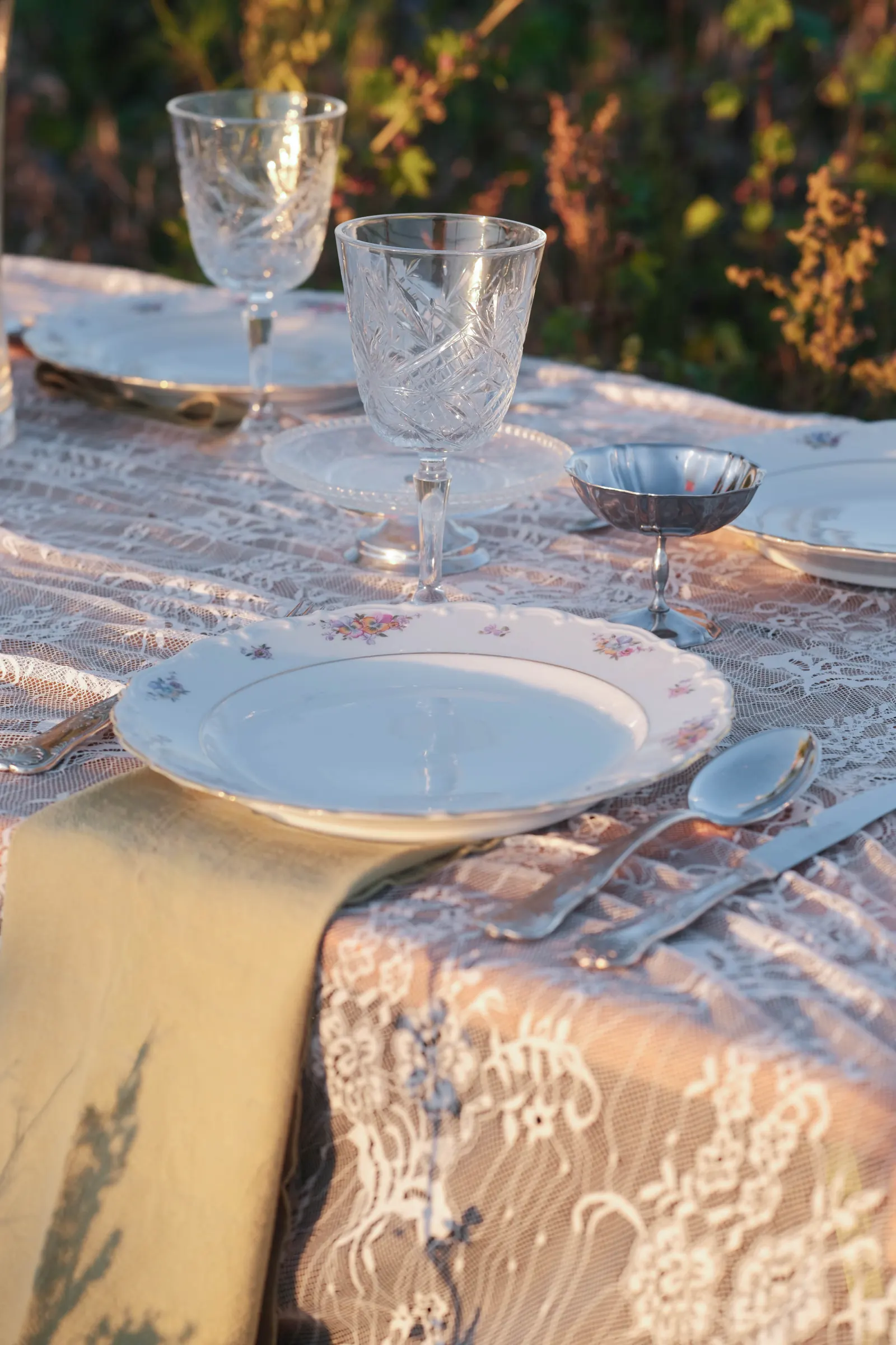 Vintage servies, glaswerk en bloemen op een gedekte tafel