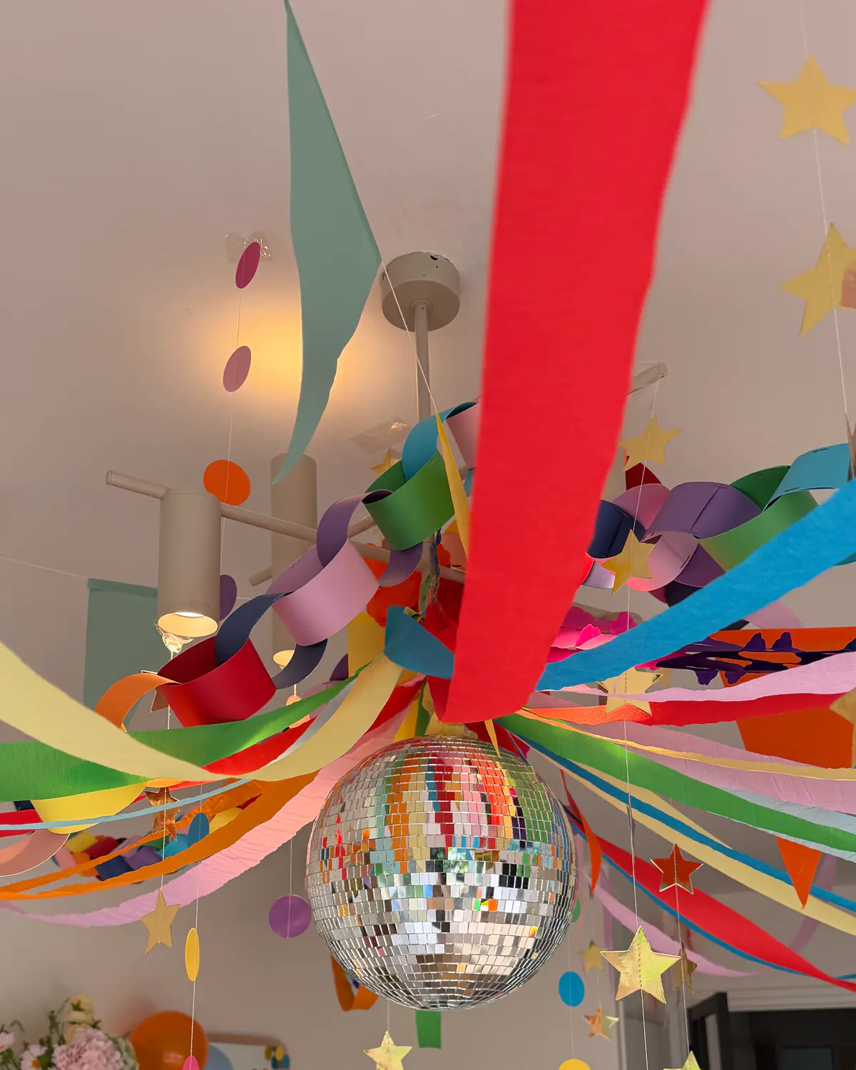 Kleurrijke slingers, papieren kettingen en een discobal als feestelijke eventaankleding